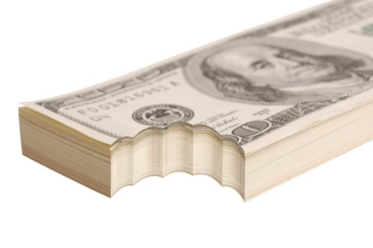 stack of $100 bills with a bite taken out of the bottom left corner of the entire stack