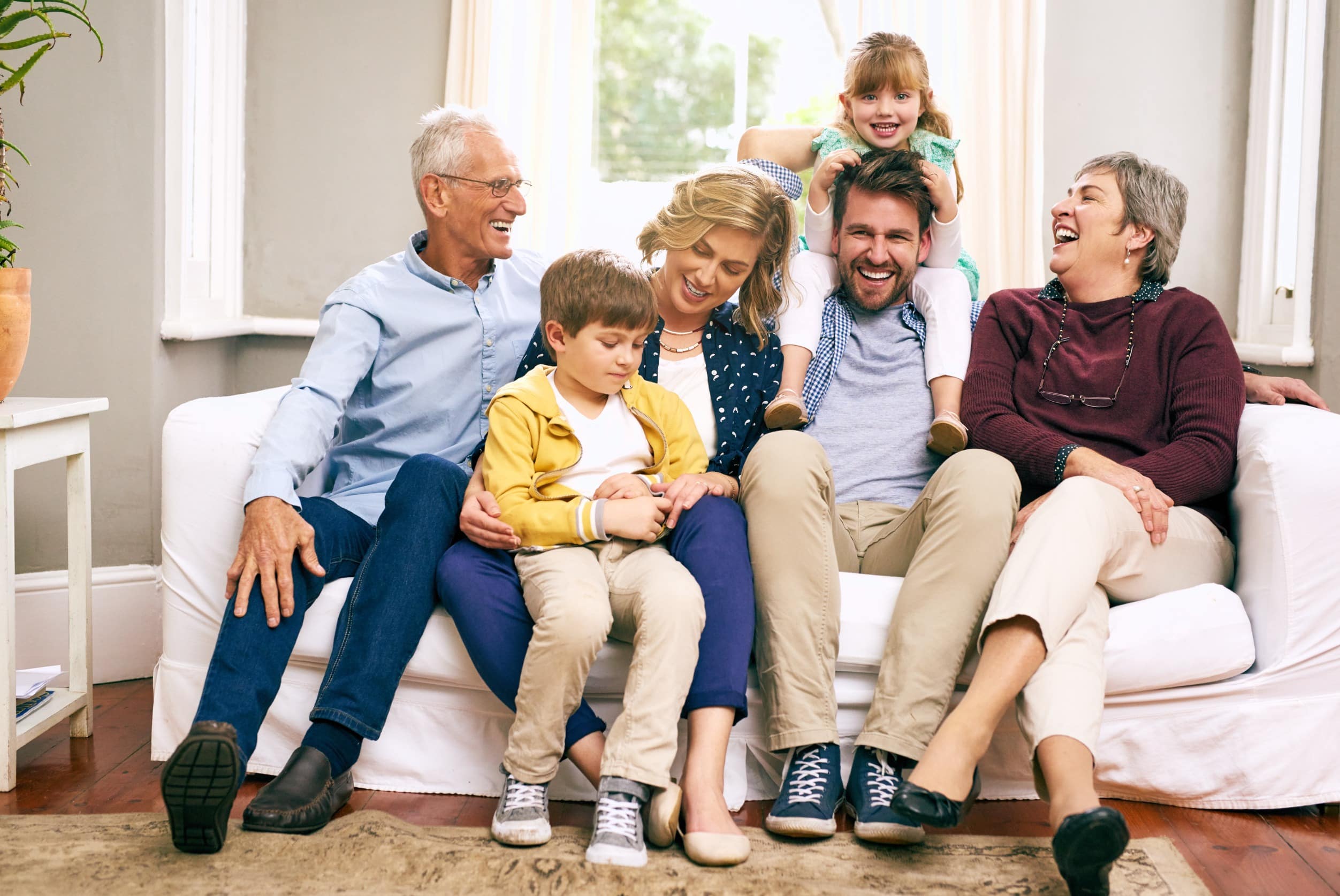 A multigenerational family sitting on the sofa at home.