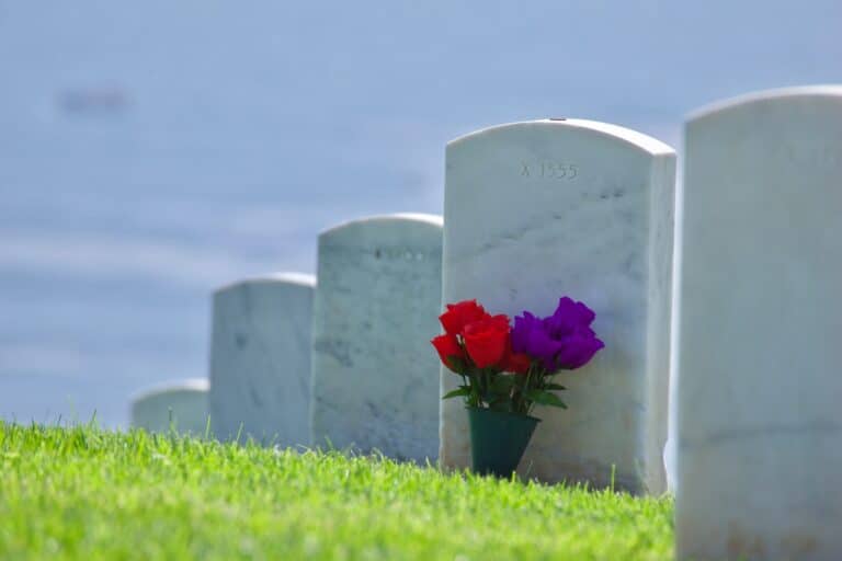 Flowers on a green hillside at a cemetery overlooking the ocean